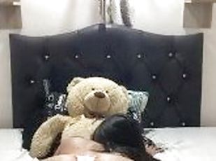 Beautiful brunette rides her teddy bear in her bedroom
