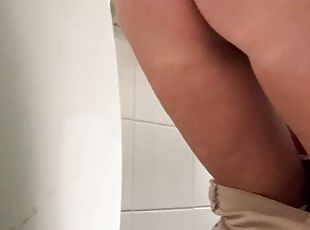 girl peeing over the toilet in a public toilet